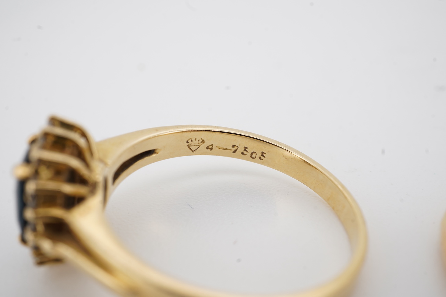 A modern 18ct gold, single stone sapphire and two stone diamond set ring, size O, an 18k, sapphire and diamond set oval cluster ring, size M/N and an 18ct, single stone sapphire and two stone diamond chip set navette sha